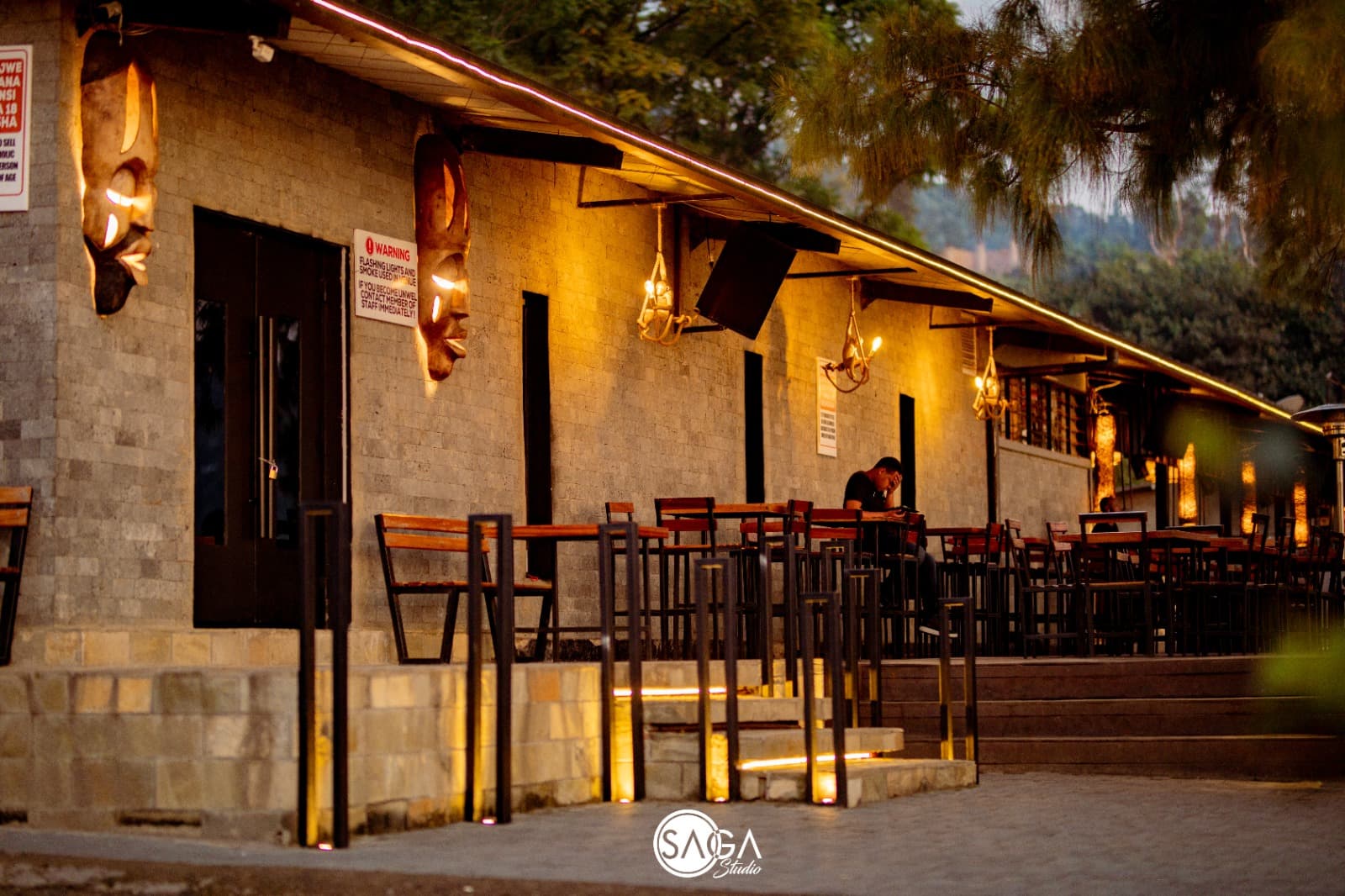 The Saga Bay bar at dusk with warm lights and stools along the front
